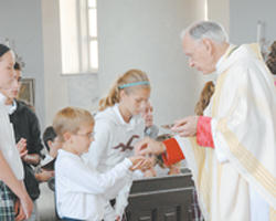 Image of Bishop Hermann gives the Most Blessed Sacrament to children.he is a beloved Bishop and a faithful priest. He is also a courageous champion for life.