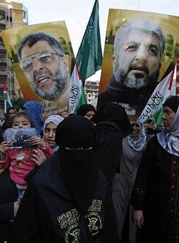 Image of Young protesters hold banners showing the faces of assassinated Hamas leader Abdel Aziz Rantissi (L) and exiled leader Khaled Meshaal (R) during a demonstration outside the Egyptian embassy in Beirut. Meshaal called on Saturday for Palestinians to wage a new intifada against Israel, including a return to suicide missions.