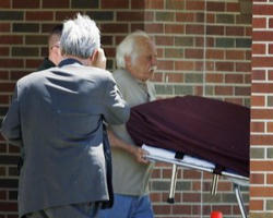 Image of Goerge Tiller being carried away after being shot to death.