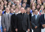 Image of the President of Wyoming Catholic College, Fr. Robert W. Cook, surrounded by happy students.