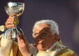 Image of Pope Benedict XVI elevates the sacred Body and Blood of Christ under the sacramental sign of wine in Bellahouston Park, Glasgow.