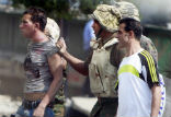 Image of An Egyptian soldier arrests two protesters on Friday.