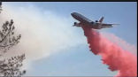 Image of This amateur photograph shows a DC-10 tanker dropping retardant on one of the Texas wildfires. 