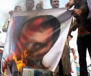 Image of Protesters burn an image of Syrian President Bashar Al-Assad as the rebellion spreads.