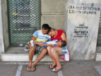 Image of Without food or medicine a Greek family sits outside a local hospital in despair. 