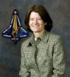 Image of Sally Ride in front of the mission patch for STS-107 (Columbia). Ride served on the boards that investigated both the Challenger and Columbia accidents. 
