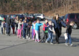 Image of children being led out of the school