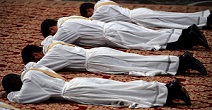Image of Deacons lie prostrate in submission to God as they are called forth to ordination to the priesthood