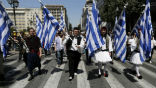 Image of Greek civil servants, dressed in traditional garb, protest pending cuts to their jobs. 