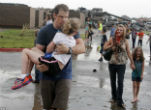 Image of Injured parents walk home after rescuing their children from the destruction at their school where at least 20 other kids perished. 