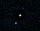 Image of The light of the parent star is blocked out and the planet is the bright blue dot to the lower left. 