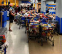 Image of A customer takes a photo of the aftermath, aisles of overstuffed carts left for employees to restock as credit limits and order were restored. Where's the shame?