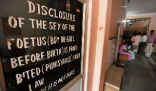 Image of A sign in a hospital in India warns that sex-determination of a child before birth is prohibited under law. 