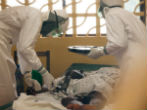 Image of A medical team take care of an Ebola infected boy in Liberia.