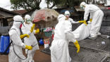 Image of Aid workers in protective suits deal with Ebola infected patients.