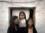 Image of The daughters of Asia Bibi, with a photograph of their mother.
