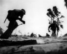 Image of U.S. Marines advance while under fire from Japanese defensive positions.