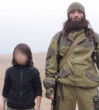 Image of A young boy, no older than 10, is seen shooting two men in ISIS' new video.