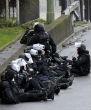 Image of Police and SWAT team sit outside kosher deli market in Paris where Amedy Coulibaly has reportedly taken six hostages. 