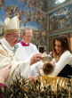 Image of Pope Francis baptizing a child in Rome.
