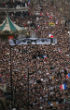 Image of Millions gathered in Place de la Republique on Sunday, Jan. 11 to take a stand against terrorism. Multiple cards held up, display the glasses and eyes of murdered Charlie Hebdo editor, Stephane Charbonnier.