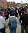 Image of A prayer circle forms amidst the Baltimore riot destruction.  (Deborah Weiner/WBAL-TV)
