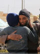 Image of The ISIS militants are photographed hugging the blindfolded accused gay men.