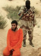Image of An Islamic State fighter, about to execute an Egyptian man accused of spying for Israel.