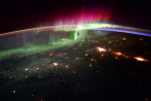 The aurora are caused by charged particles that are drawn into the atmosphere by Earth's magnetic field where they strike gas molecules, causing them to glow.