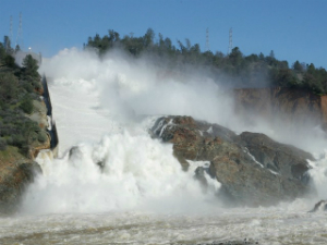 Water rushes down the spillway and into the eroded area outside the dam. Erosion is threatening the integrity of the system and up to a quarter million people could be affected.