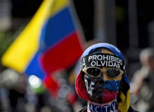 A protestor wears a bandana that reads, 'prohibited to forget.'