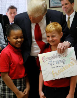 President Trump posed for a picture with two students from St. Andrew Catholic School, telling them 'Come on, kids. We're going to make you famous.' (CNS)