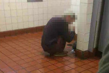 An addict huddles on the floor of a public restroom. Opioids cause the user to stop caring about things most people care about.