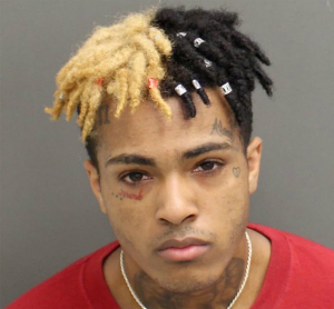 Racist thug, XXXTentacion in his latest mugshot for violent behavior. His video, which shows him lynching a child, has gone viral, earning him a payout from YouTube.