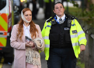 An injured woman is escorted away from the site of the attack where 22 people were injured.