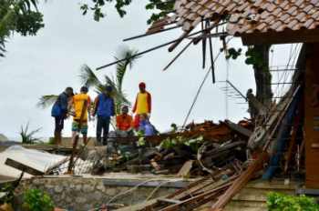 Officials look through the wreckage of damaged buildings in Carita, Indonesia on December 23, 2018. Credit: AFP/Getty Images.