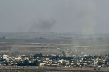 Smoke rises from the Syrian town of Ras al Ayn during the Turkish offensive against Kurdish groups in northeastern Syria Oct. 17 2019 as seen from Turkey.