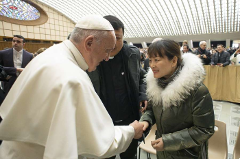 Image of Pope Francis greets a woman after the general audience