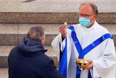 Image of Canon Law does not have rules regarding priests and masks while administering the Sacraments. However, there should be some limits observed when it comes to COVID restrictions. 