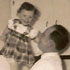 Image of TENDER MOMENT - A father, George, balances his daughter, Mary, on his hand in the family kitchen. George's journey of faith and hope is revealed in this Father's Day story.
