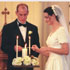 Image of LET THERE BE LIGHT A Catholic couple lights candles during their wedding celebration.