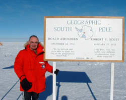 Image of PRIEST STANDS NEXT TO SIGN AT SOUTH POLE – Father John Harrison, a priest of the Diocese of Dunedin, New Zealand, stands next to a sign at the South Pole in 2003. Father Harrison is in his fifth year as a chaplain at McMurdo Station in Antarctica, where 1,000 people or more work each year on National Science Foundation projects or in support services for the researchers. (CNS/courtesy of Father Harrison)
