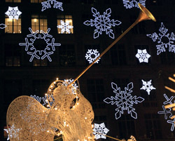 Image of ANGELS ON NEW YORK CITY’S FIFTH AVENUE – Lighted herald angels are seen in front of snowflakes projected on the front of Saks Fifth Avenue in New York Nov. 30. The angels have been part of the Rockefeller Center's annual Christmas display for 20 years. (CNS)
