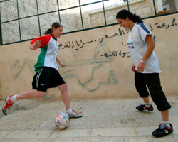 Image of WOMEN PLAY SOCCER ON STREET IN BETHLEHEM - Marian Al Bandak, 17, and her neighbor, Honey Thaljieh, 22, play soccer on the street between their houses in Bethlehem in the West Bank Dec. 6. Both are members of the Palestinian Women's National Soccer League. Although Palestinians have traditionally regarded soccer as a man's sport, younger generations of women have defied tradition and often the will of their families by playing the sport. (CNS photo/Debbie Hill) 