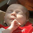 Image of INDIANAPOLIS BABY BORN WITH RARE TUMOR SLEEPS IN FATHER'S ARMS - Anne Therese Felts of Indianapolis sleeps in her father's arms in early February. At 27 weeks gestation, the fourth child of St. Simon the Apostle parishioners Chris and Paje Felts of Indianapolis was diagnosed with having a rare pericardial teratoma -- a racquetball-size tumor attached to her heart. She overcame overwhelming odds during the hours and days after her premature birth Dec. 28, 2006. (CNS photo/Mary Ann Wyand, The Criterion)