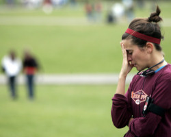 Image of STUDENT GRIEVES AT MEMORIAL TO SHOOTING VICTIMS – A student grieves at a campus memorial for the Virginia Tech shooting victims in Blacksburg, Va., April 19. Student Cho Seung-Hui, 23, killed 32 people and then took his own life April 16 at the university. (CNS/Reuters)