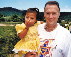 Image of DOCTOR SHARES MEDICAL SKILLS - Deacon Dr. Don Greenway holds a 3-year-old Honduran patient in the village of Guadalupe Carney during the March 2004 Christ the King medical mission. (Photo Arkansas Catholic)
