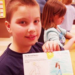 Image of THE STATIONS, ILLUSTRATED - Second grader Zach Olds displays one of the pages in his booklet. (Catholic Herald/Mary Grieco) 