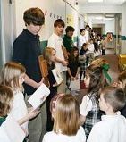 Image of STATION TO STATION - Sophomore theology students from Archbishop Bergan Catholic High School hold the Stations of the Cross while kindergartners and first graders at Archbishop Bergan Elementary move from station to station Feb. 22. Reading the station is Lauren Glowacki. (Lisa Maxson/Staff)
<br>