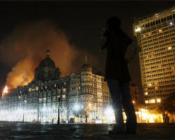 Image of A woman reacts, during a candle-light march for the victims of the Mumbai terrorist attack in which more than 195 people were killed, in Mumbai, India.